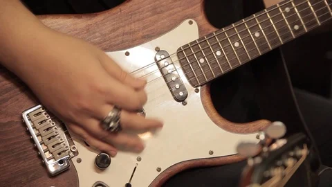 Male hands with a ring playing a brown and white electric guitar Stock Footage 98290072