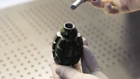 Male hands in rubber gloves spin a grenade Stock Footage 222102553
