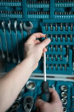 Male hands select screwdriver tip. Stock Photos