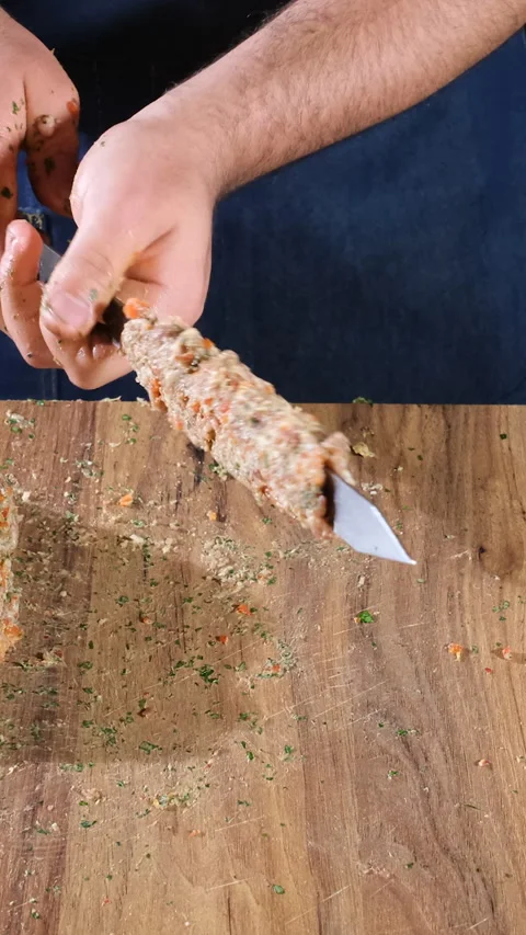 Male hands shaping minced meat on a metal skewer Stock Footage 345417268
