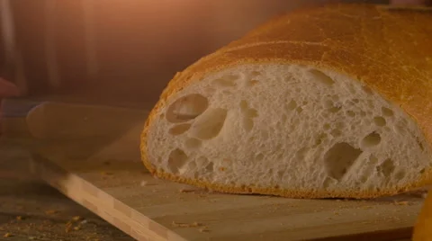 Male hands slicing fresh bread on wood table Stock Footage 62839963