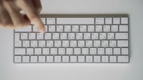 Male hands slowly learning to type on a white computer keyboard. Table top view. Vídeo Stock 158891286