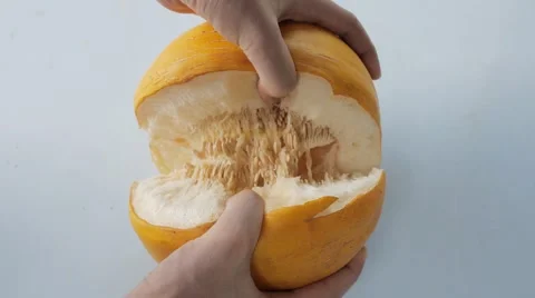 Male hands split yellow ripe melon into two halves and take out seeds. Close up. Stock Footage 68366442