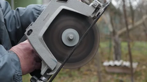 Male hands turn on spinning circular saw Stock Footage 342867968