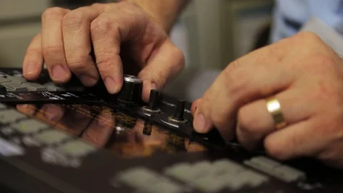 Male hands turning knobs on an electronic console. Close up shot of hands. 動画素材 116253341