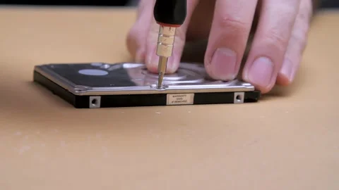Male hands twists the screw on a computer hard drive with a screwdriver. 動画素材 132648370
