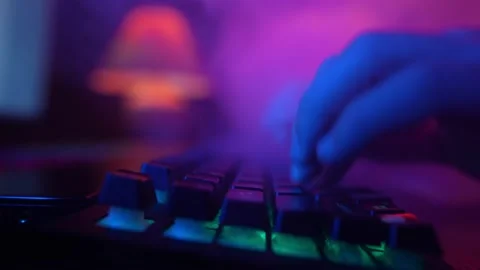 Male Hands Typing on Computer Keyboard in Neon Lighting. Hacker and Cyber Crimes Stock Footage 232613103