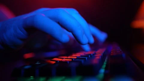 Male Hands Typing on Computer Keyboard in Neon Lighting. Hacker and Cyber Crimes Stock Footage 252096106