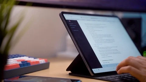 Male hands typing on keyboard of iPad Pro on desk, writing text, work Stock Footage