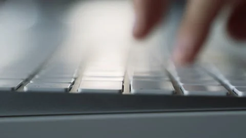 Male hands typing on a white computer keyboard. Macro. Slide zoom in. Vídeo Stock 158891141