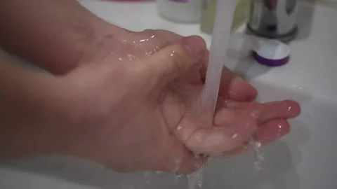 Male hands under a stream of clean running water, close-up Stock Footage 153385455