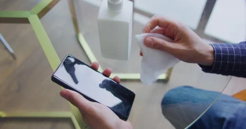 Male hands using alcohol cleaning and disinfect mobile phone screen in self Stock-Footage 132013536