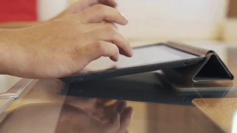 Male hands using cased tabled upon glass coffee table desk, playing video game Vídeo Stock 73029447