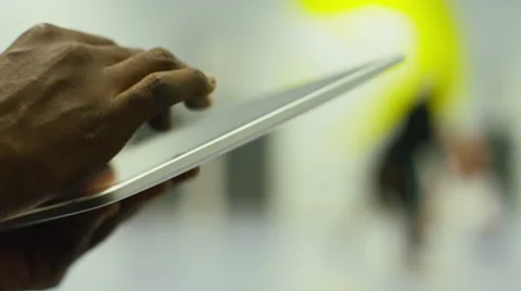 Male hands using a digital tablet as players in the background play basketball Stock Footage 46012044