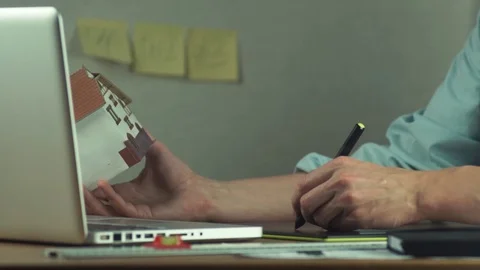 Male hands using graphic tablet creating housing project on laptop Stock Footage 81880661