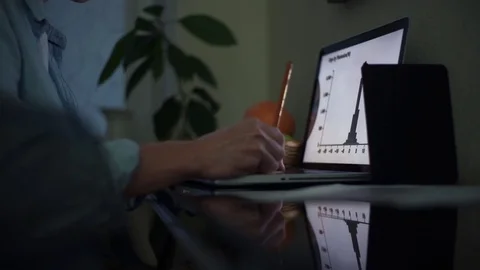 Male hands using laptop in kitchen in evening Stock Footage 82937726