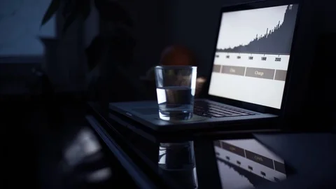 Male hands using laptop in kitchen at night. Glass of water and pencil on table Stock Footage 82937967