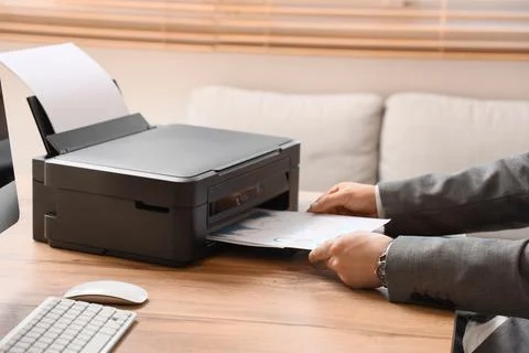 Male hands using printer on desk in office Stock Photos