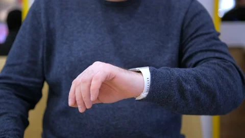 Male hands using smart watch in shopping mall. The man has a pulse. Health care Stock Footage 232494715