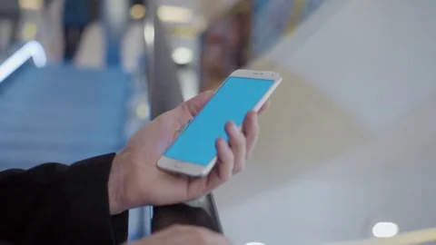 Male hands using smartphone with blue screen in shopping mall Video stock 74162316