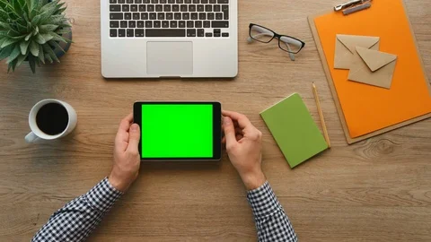 Male hands using tablet computer with green screen on wooden background with Stock Footage 74685135