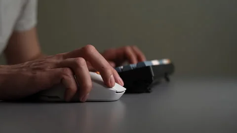 Male hands using white wireless computer mouse and mechanical keyboard on gray Stock-Footage 342763137