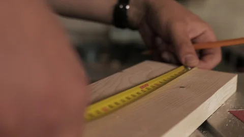 Male hands using a yellow tape measure to measure a piece of wood Stock Footage 110341128