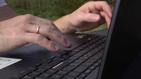 Male hands with a wedding ring work on a laptop, the keyboard is close-up Stock Footage 255949304