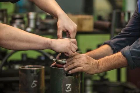 Male hands working spin parts in an old factory to install the equipment Stock Photos