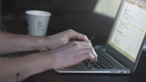 Male hands writing code and taking a cup of coffe from table. Hacker api text on Stock Footage 105654914