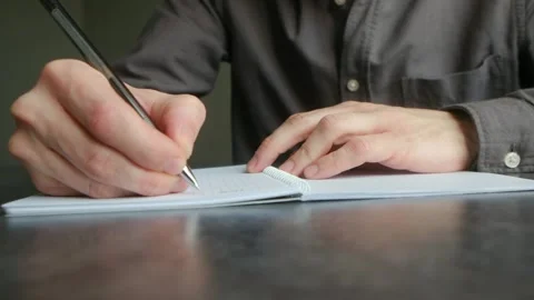 Male hands writing notes in a notebook Vidéo 337892348