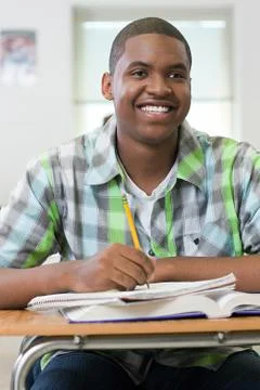 Male high school student working in classroom Foto stock