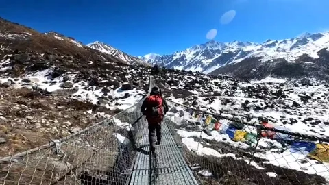 Male hiker crossing the bridge in the mountain. Stock Footage