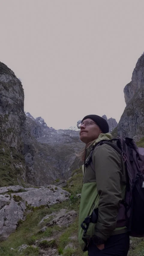 Male hiker observing dramatic mountain scenery with snowy peaks Video stock 336726215