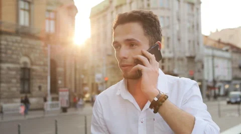 Male in his 20s have a serious talk on phone and then reacting with a wide smile Stock Footage 59797872