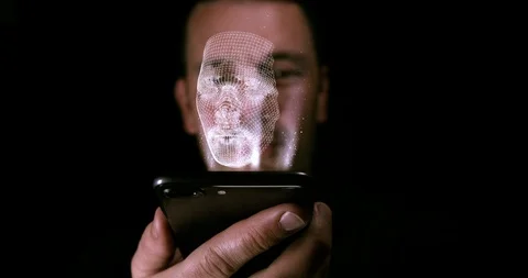 Male holding a digital device with a 3D imprint of his face as a hologram. Stock Footage 97234853