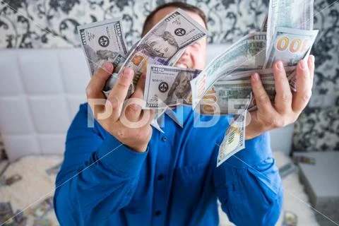 Male holds in his hands a lot of money. A man enjoys a lot of cash dollars Stock-Fotos