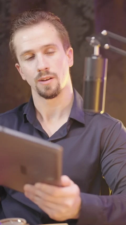 Male host with tablet computer on live podcast listening to guest Stock Footage 324960198