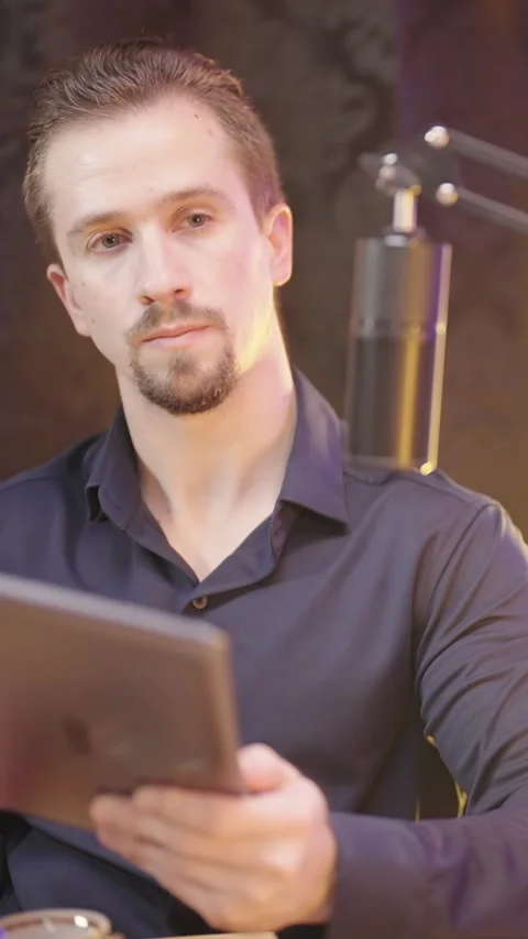 Male host with tablet computer on live podcast listening to guest Stock Footage 324960204