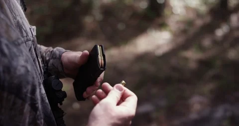 Male hunter loading bullets into a magazine Stock Footage 107629892