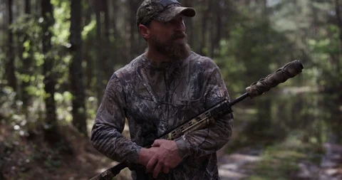 Male hunter walking through a forest with a rifle Stock Footage 107629751