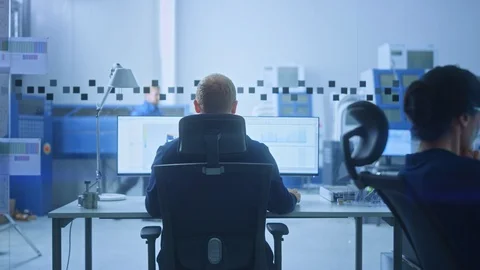 Male Industrial Engineer Solving Problems, Working on a Personal Computer, Two Stockbeeldmateriaal 124457017