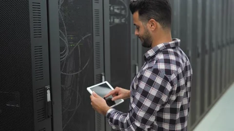 Male informatic engineer working inside server room database Stock Footage 149887382