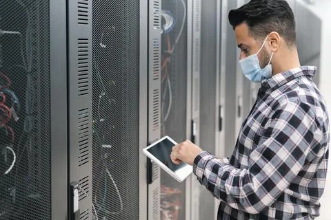Male informatic engineer working inside server room database Stock Photos