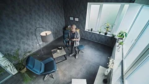 Male installer sets up angle of CCTV camera, uses tablet Stock Photos