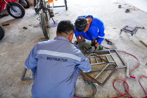 The male instructor is demonstrating welding process Stock Photos