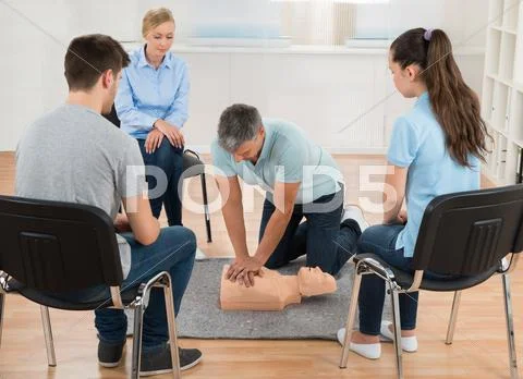 Male Instructor Teaching First Aid Cpr Technique To His Students Stock Photos