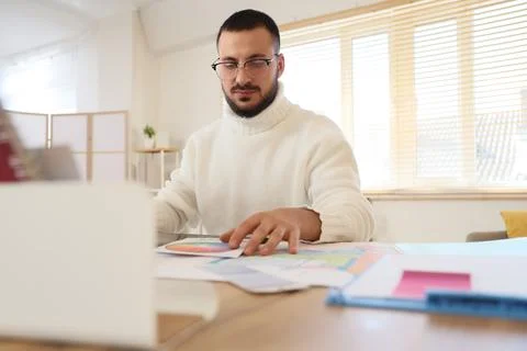 Male interior designer working at table in office Stock Photos