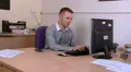 Male is interupted by a folder being placed on his desk HD Footage