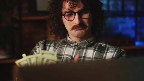 Male IT developer counting money in front of retro computer, e-business success Stock Footage 321084660